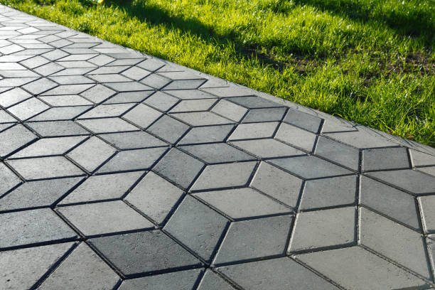 The footpath in the park is paved with diamond shaped concrete tiles.